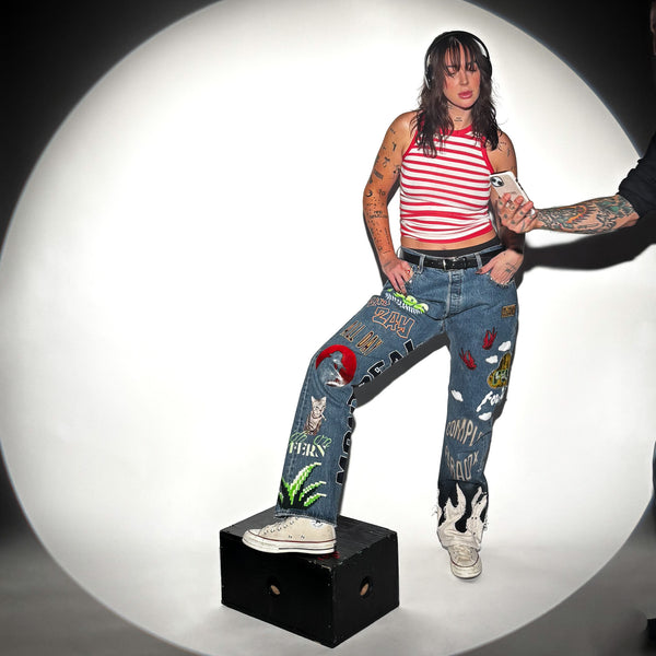 Model wearing custom hand-painted denim jeans made for Fouki by Complex Paradox
