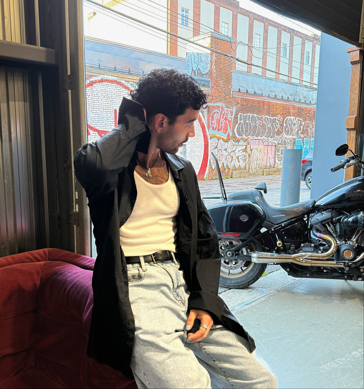 Model in CMPLX black button-down shirt layered look beside motorcycle, Complex Paradox streetwear
